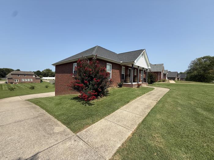 Brick ranch home with a freshly cut front lawn and crepe myrtle