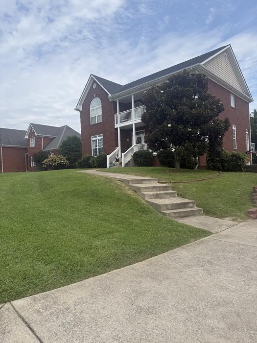 Two-story brick home with a cut and edged front lawn